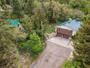 Aerial view of property and surrounding area with a forest