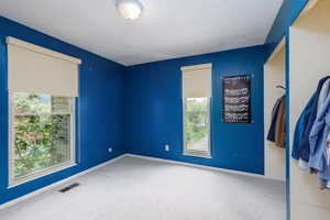 Empty room with carpet floors, healthy amount of natural light, baseboards, and a textured ceiling