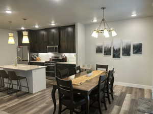Dining area with dark wood finished floors, recessed lighting, a chandelier, and baseboards