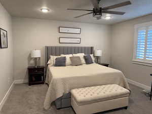 Bedroom featuring carpet flooring, baseboards, and a ceiling fan