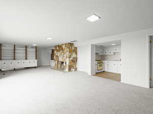 Unfurnished living room with light carpet and a fireplace