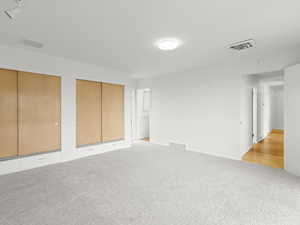 Unfurnished bedroom featuring multiple closets and light carpet