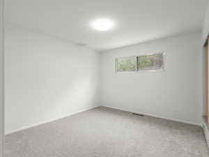 Unfurnished room featuring carpet floors and baseboards