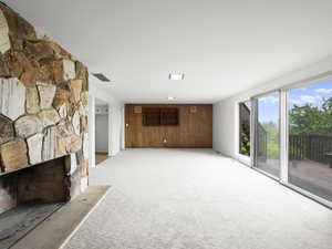 Unfurnished living room with light carpet and a fireplace