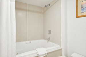 Full bathroom featuring shower / tub combo with curtain and toilet