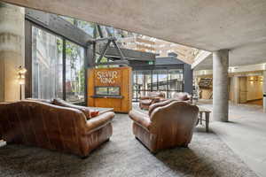 Living area with decorative columns and vaulted ceiling