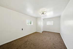 Carpeted spare room with plenty of natural light and baseboards