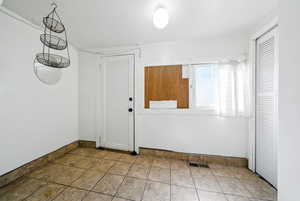 Foyer with baseboards and tile patterned floors
