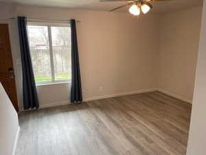 Empty room featuring a ceiling fan, wood finished floors, and baseboards