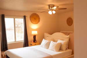 Bedroom with multiple windows and ceiling fan