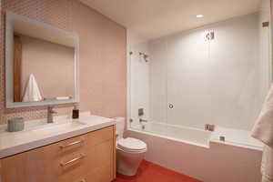 Bathroom with toilet, tiled shower / bath, vanity, tile patterned flooring, and recessed lighting