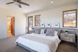 Carpeted bedroom featuring baseboards, recessed lighting, connected bathroom, and ceiling fan