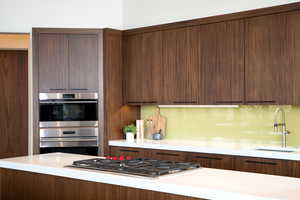 Kitchen with appliances with stainless steel finishes, a sink, and modern cabinets