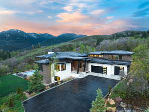 Prairie-style home featuring driveway, a mountain view, a garage, and stucco siding