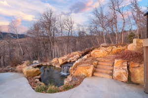 Pool at dusk featuring a garden pond
