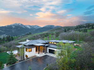 View of front of property featuring a garage, a mountain view, and driveway