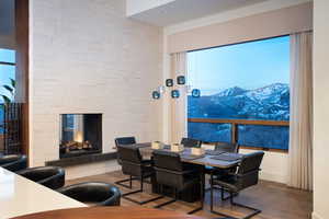 Dining space featuring a stone fireplace, wood finished floors, and a mountain view