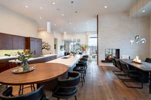 Kitchen featuring a sink, modern cabinets, a kitchen island with sink, open floor plan, and light countertops