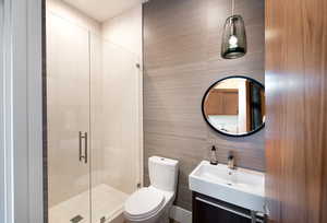 Bathroom with a stall shower, toilet, and vanity