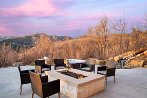 Patio terrace at dusk with a fire pit and a mountain view