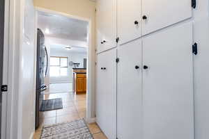 Floor to ceiling built in cabinets line the hallway leading from kitchen to laundry room, backyard, and downstairs