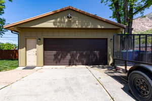 Detached garage featuring fence and a mountain view