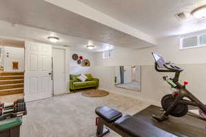 Bedroom with full size closet, carpet, a textured ceiling, baseboards, and healthy amount of natural light