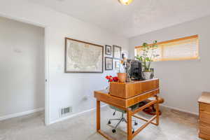 Carpeted home office with light walls, carpet, and baseboards