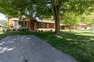 Front yard featuring a separate paved parking stall