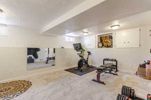 Bedroom with full size closet, carpet, a textured ceiling, baseboards, and healthy amount of natural light