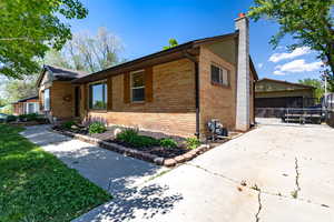 View of property exterior with brick siding, driveway, and garage