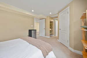 Bedroom featuring light colored carpet, baseboards, and recessed lighting