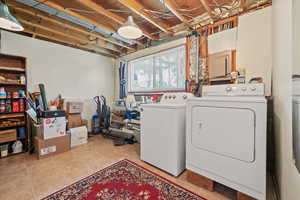 Laundry area featuring washer and dryer and light tile patterned flooring