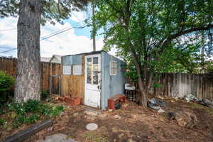 View of potting shed with a fenced backyard