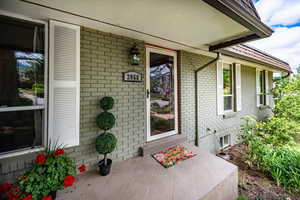 Property entrance with brick siding and a porch
