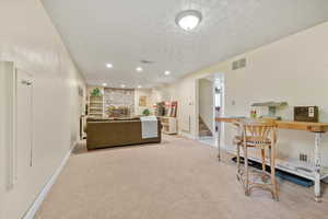 Office space featuring a textured ceiling, carpet floors, a fireplace, recessed lighting, and baseboards