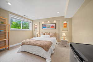 Bedroom with light colored carpet and baseboards