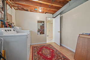 Laundry area featuring washer and clothes dryer, light tile patterned floors, baseboards, and wood ceiling