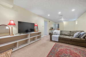 Living area with carpet, recessed lighting, a textured ceiling, and baseboards