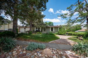 View of front of property featuring a front yard, an attached garage, and brick siding