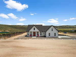 Modern inspired farmhouse featuring board and batten siding, a porch, and a view of rural / pastoral area