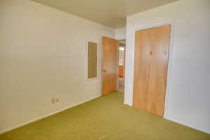 Unfurnished bedroom featuring carpet floors, a closet, and baseboards