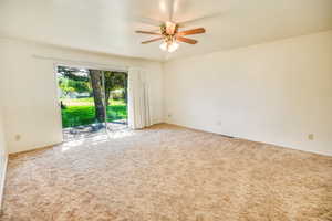 Carpeted spare room with ceiling fan
