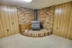 Detailed view of a wood stove, carpet floors, and wood walls
