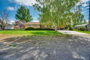 View of front facade featuring driveway and a front yard