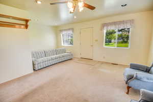 Living area featuring plenty of natural light, ceiling fan, carpet floors, and recessed lighting