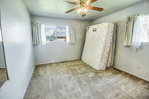Unfurnished bedroom featuring carpet flooring, baseboards, and a ceiling fan