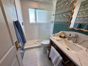 Main Hall bathroom with toilet, vanity, and a tile shower