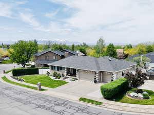 View of front of house with a garage, driveway, stone siding, and a residential view
