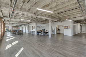 Miscellaneous room with an office area, wood finished floors, and baseboards